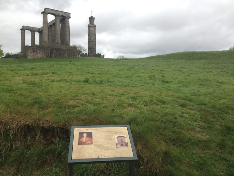 Moments on a grassy hill with interpretive sign below