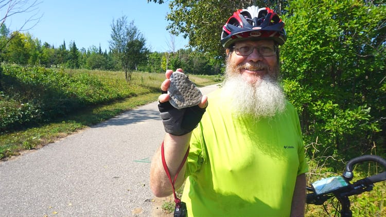 Cyclist holding a Petoskey stone